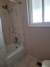 Bathroom featuring shower / bath combo, visible vents, baseboards, toilet, and tile patterned flooring