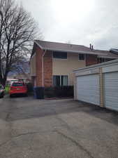 View of front of home featuring the detached garage and brick siding
