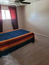 Bedroom featuring carpet floors, baseboards, and ceiling fan