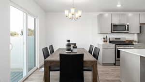 Dining area featuring light wood-style flooring, an inviting chandelier, and recessed lighting