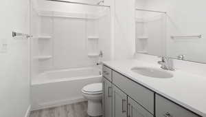 Bathroom featuring bathing tub / shower combination, vanity, toilet, and wood finished floors