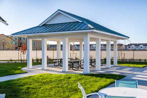 View of property's community featuring a gazebo, fence, a patio, and a lawn