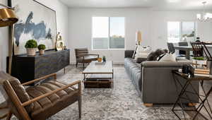 Living room featuring a chandelier, baseboards, and wood finished floors
