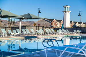 View of swimming pool featuring a patio and fence