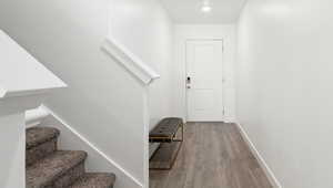 Stairway featuring baseboards and wood finished floors