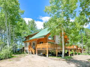 View of front of house featuring a wooden deck and metal roof