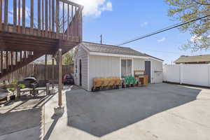 View of patio featuring an outbuilding, a fenced backyard, and stairway