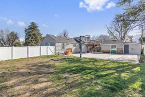 View of yard with a patio area, a fenced backyard, and an outbuilding