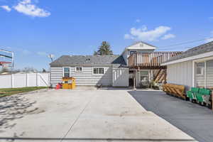 Rear view of house with a shingled roof, fence, a patio, and stairs