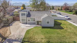 View of front of home featuring a front yard, a fenced backyard, a mountain view, and a shingled roof