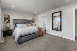 Primary bedroom featuring recessed lighting, carpet, visible vents, and baseboards
