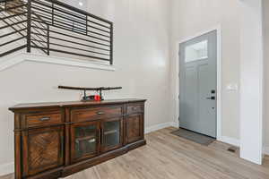 Entrance foyer with visible vents, baseboards, and light wood-type flooring