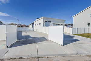 View of home's exterior with a patio area, a fenced backyard, an outdoor structure, and board and batten siding