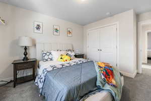 Carpeted bedroom featuring a closet and baseboards