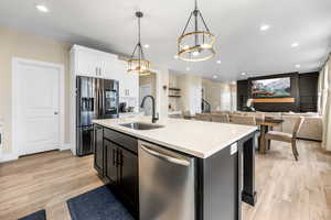 Kitchen with white cabinets, a sink, a chandelier, recessed lighting, and stainless steel appliances