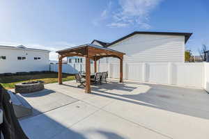 View of patio featuring a gazebo, a fenced backyard, and a fire pit