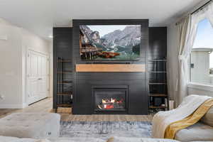 Living room with wood finished floors, a fireplace, and baseboards