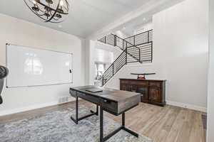 Office with visible vents, baseboards, light wood-type flooring, and a chandelier