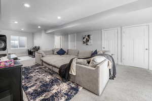 Living room with carpet floors, baseboards, recessed lighting, and a textured ceiling