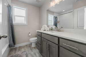 Bathroom with visible vents, toilet, wood finished floors, and a healthy amount of sunlight