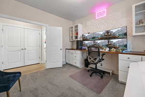 Office featuring light carpet and built in study area
