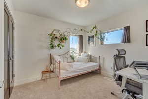 Bedroom with baseboards and light carpet
