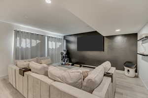 Living room with recessed lighting, light wood-type flooring, and baseboards
