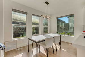 Dining space featuring visible vents, baseboards, light wood-type flooring, and a notable chandelier