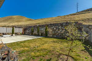 View of yard featuring a patio area, fence, and a mountain view