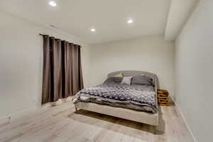 Bedroom with recessed lighting, light wood-style floors, and baseboards