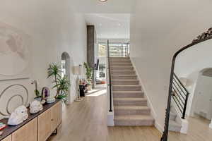 Staircase featuring visible vents, baseboards, recessed lighting, and wood finished floors