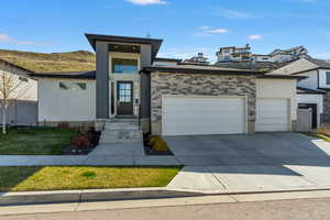 Prairie-style house featuring a garage, stucco siding, and concrete driveway