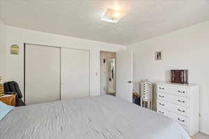 Bedroom featuring a textured ceiling and a closet