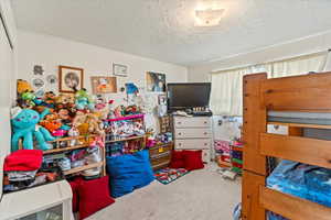 Bedroom with carpet and a textured ceiling