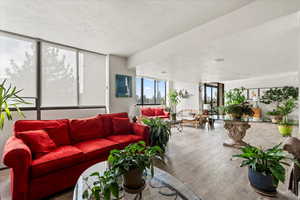 Interior space featuring a textured ceiling, wood finished floors, and floor to ceiling windows