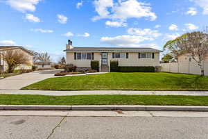 Single story home featuring crawl space, fence, a front lawn, a chimney, and concrete driveway