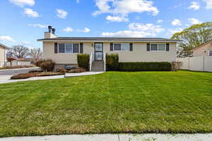 Single story home with a front yard, fence, and a chimney