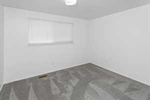 Spare room featuring visible vents, baseboards, and carpet
