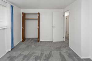 Unfurnished bedroom with a closet and carpet floors