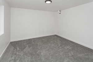 Spare room with baseboards and carpet