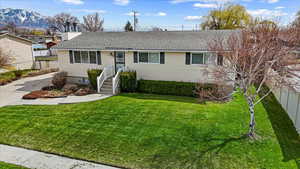 Single story home with a front yard, a mountain view, fence, and roof with shingles