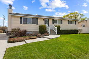 Ranch-style home featuring fence and a front lawn