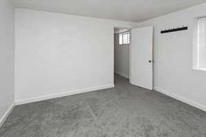 Carpeted empty room with baseboards