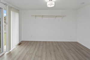 Spare room featuring visible vents, baseboards, plenty of natural light, and light wood-style floors