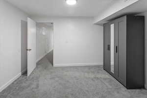 Finished below grade area featuring baseboards and carpet floors