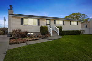 Ranch-style home with a front yard and fence