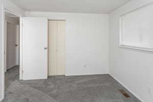 Unfurnished bedroom featuring visible vents and carpet flooring