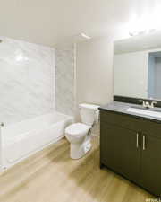 Full bathroom featuring vanity, bathing tub / shower combination, a textured ceiling, toilet, and wood finished floors