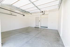 Garage featuring baseboards and a garage door opener