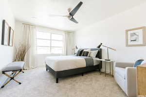 Bedroom with light carpet, baseboards, and ceiling fan